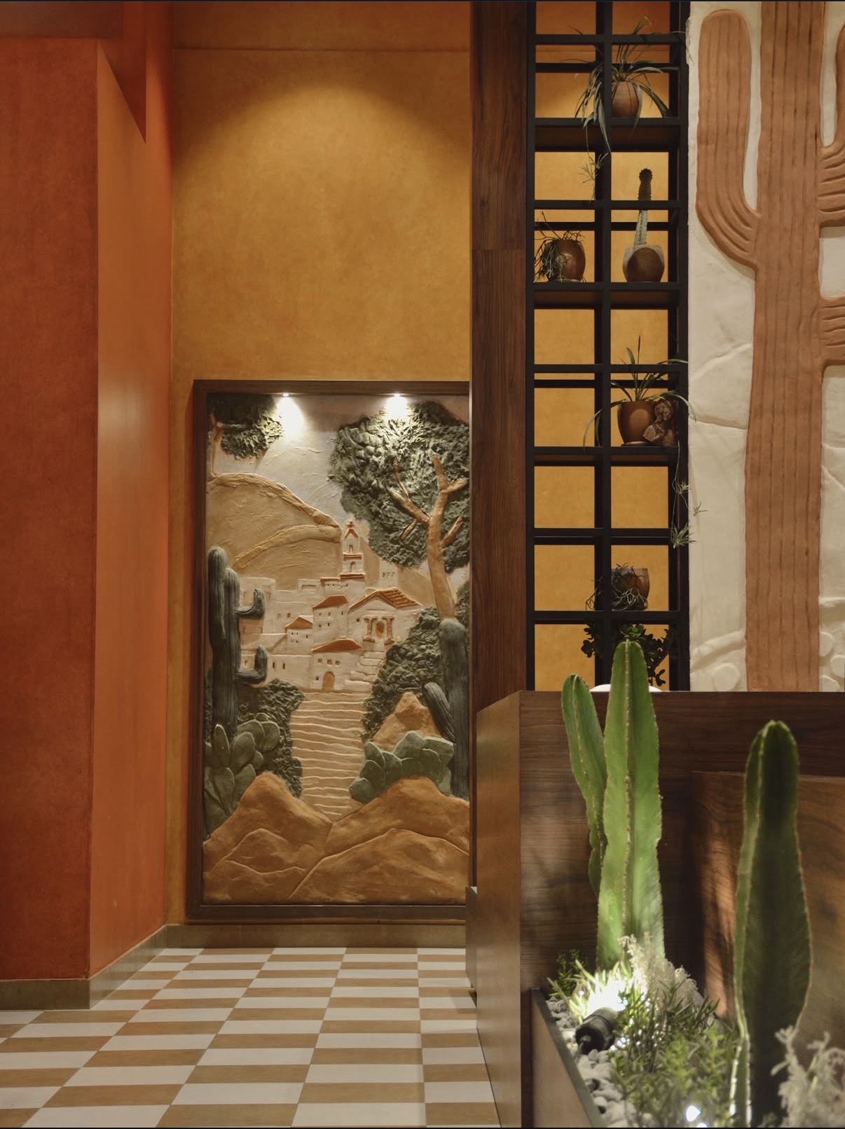 Mural de bajorrelieve con pueblo colonial y cactus